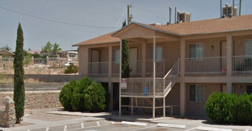 an apartment building with a balcony and a parking lot